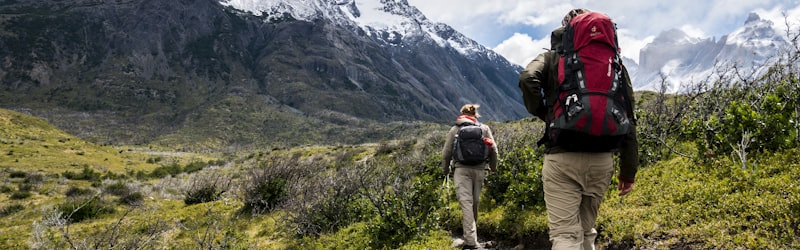 专业登山装备套装展示，包括登山靴、冲锋衣、登山杖等，背景为雪山
